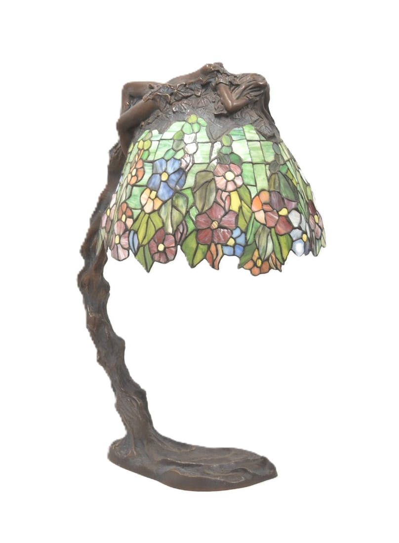 AFTER EMIL THOMASSON BRONZE STAINED GLASS LAMP: AFTER EMIL THOMASSON , BRONZE TREE FROM LAMP WITH BRONZE RECLINING NUDE WOMAN LAYING ON TOP OF FLORAL STAINED GLASS SHADE , SIGNED E THOMASSON - 17" x 13 1/2" x 28 1/2"