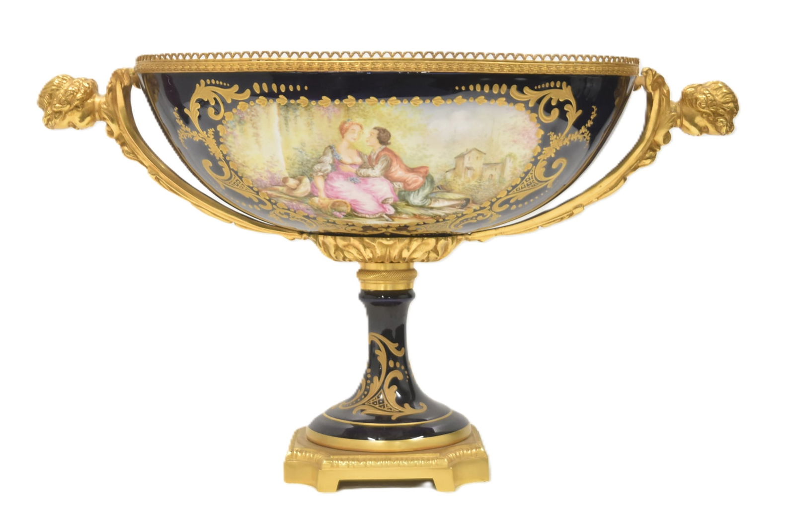 SEVRES STYLE PORCELAIN & BRONZE CENTERPIECE: DECOR MAIN FRANCE LAPIS BLUE PORCELAIN CENTERPIECE WITH FIGURAL MEDALLION SURROUNDED BY HEAVY GOLD DECORATIONS & TWIN HANDLE PUTTI HEADS - 20" x 10" x 12"