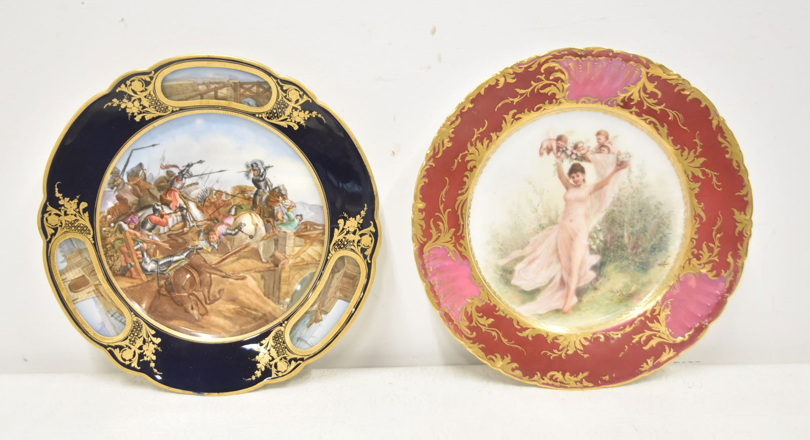 (2) HAND PAINTED CABINET PLATES: HAND PAINTED ROYAL VIENNA STYLE CABINET PLATE WITH ALLEGORICAL WOMAN WITH CHERUBS SURROUNDED BY RED & GOLD BORDER / FRENCH SEVRES STYLE BATTLE SCENE PLATE WITH (3) MEDALLIONS & AROUND COBALT & GOLD BO