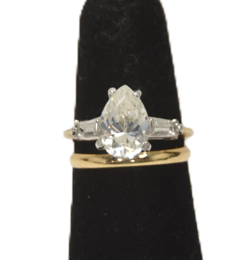 14kt 1.5ct PEAR SHADE DIAMOND ENGAGEMENT RING: APPROXIMATELY 1.5ct PEAR SHAPE DIAMOND CENTER STONE RING FLANKED WITH (2) TAPERED DIAMOND BAGUETTES ; APPROX 20 POINTS EACH ; SET IN 2-TONE 14kt GOLD SETTING - 3.96grams ; WITH 14kt GOLD WEDDING BAND