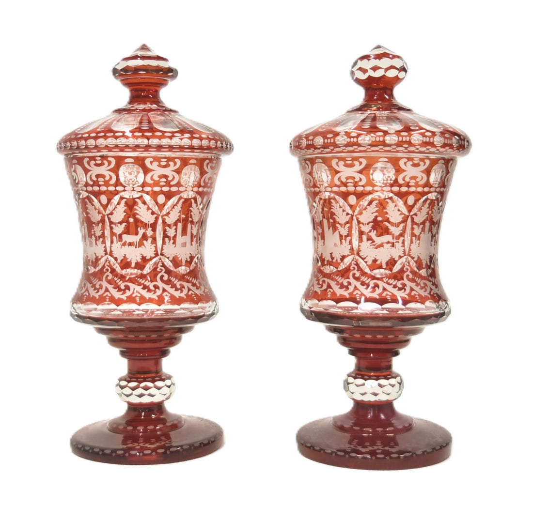 PAIR LARGE RUBY BOHEMIAN LIDDED POKALS: PAIR LARGE BOHEMIAN ETCHED RUBY GLASS COVERED POKAL VASE WITH ETCHED MEDALLIONS OF CASTLES & DEER - 8 x 17" (ONE HAS SMALL CHIP ON RIM)