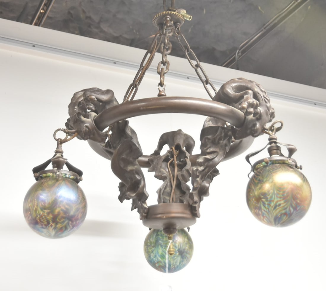 MEDIEVAL GOTHIC BRONZE DRAGON CHANDELIER: MEDIEVAL GOTHIC PATINATED BRONZE CHANDELIER WITH (3) DRAGONS HOLDING (3) IRIDESCENT ART GLASS GLOBE SHADES - 20" x 16" ; SHADES ARE 5 12" ; MEDIEVAL GOTHIC BRONZE DRAGON CHANDELIER