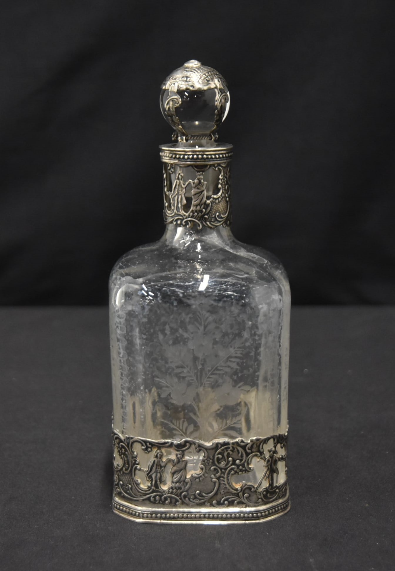 EMBOSSED STERLING SILVER MOUNTED DECANTER: EMBOSSED STERLING SILVER MOUNTED GLASS DECANTER - 2 1/2" x 2 1/2" x 7 1/2" (GLASS HAS CRACK ON TOP RIM)