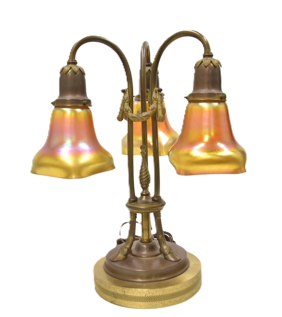 BRONZE & ART GLASS TABLE LAMP: BRONZE TABLE LAMP WITH RAM FEET & GARLANDS HAVING (3) IRIDESCENT ART GLASS SHADES - 7 1/2' x 18"
