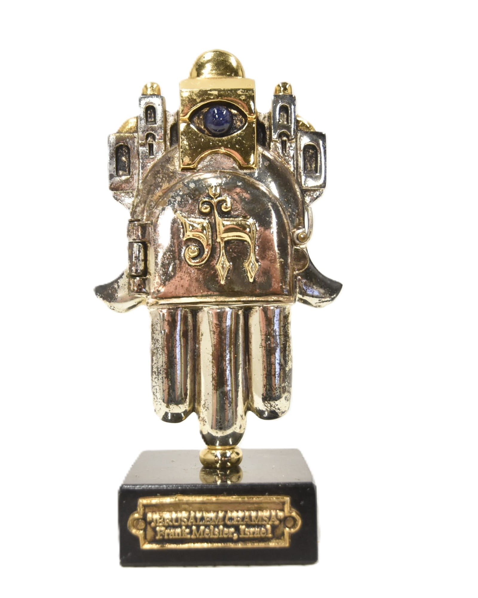 FRANK MEISLER JERUSALEM CHAMSA SCULPTURE: FRANK MEISLER (POLISH, ISRAEL - 1925-2018) JERUSALEM CHAMSA ; HAMSA MIXED METAL MENORAH SCULPTURE whimsical work depicting a Judaica luck symbol, with eye made of lapis lazuli, and featuring a front d