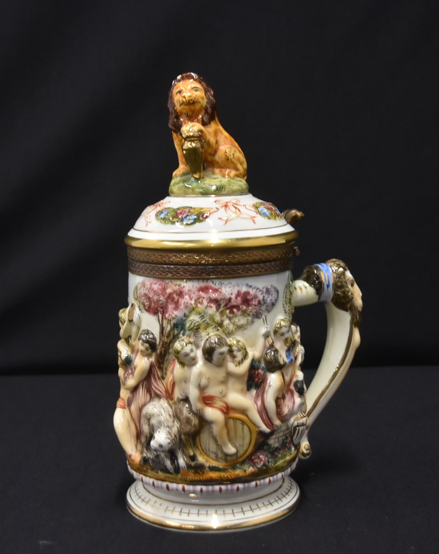 CAPODIMOMTE ITALY PORCELAIN STEIN: CAPODIMONTE PORCELAIN STEIN WITH RAISED RELIEF FIGURES ALL AROUND & LION FINIAL 6" x 10 1/2"