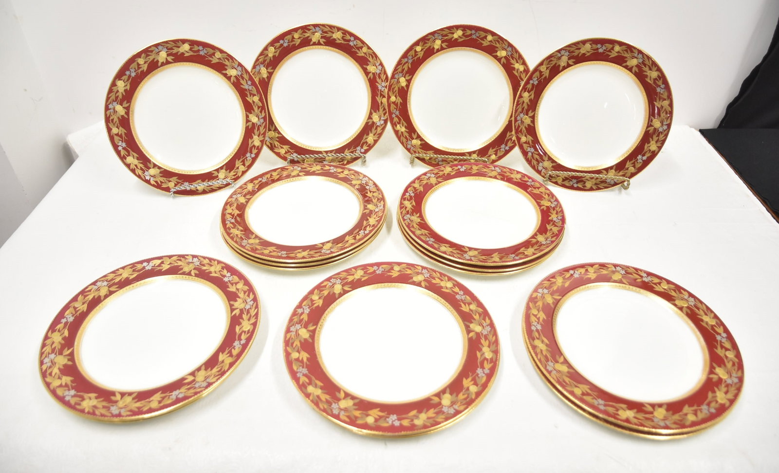 (16) BROWNFIELD TIFFANY & Co SILVER & GOLD PLATES: (16) BROWNFIELD'S TIFFANY & Co.CHINA PLATES WITH SILVER & GOLD FOLIATE & FRUIT DECORATIONS OVER MAROON GROUND PLATES - 10" DIAMETER (ONE HAS CHIP & CRACK)