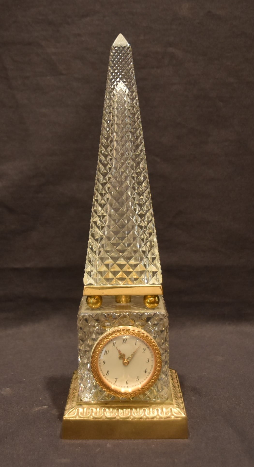 CRISTAL ET BRONZE FRENCH OBELISH CLOCK: CRISTAL ET BRONZE CUT CRYSTAL OBELISH CLOCK WITH BRONZE MOUNTS ; HAS CRISTAL ET BRONZE LABEL - 3 1/2" x 3 1/2" x 11" (CLOCK IS IN WORKING ORDER ; HAS CRACK ON SIDE OF OBELISK) (PLEASE NOTE THIS ITEM I