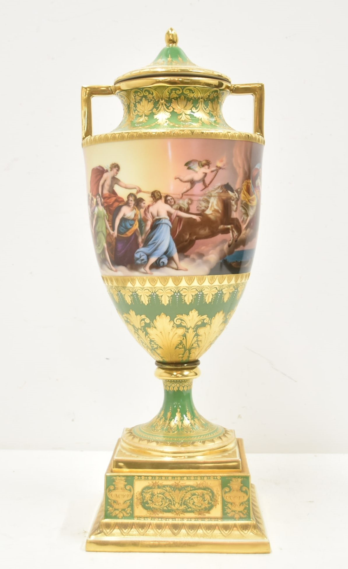 LARGE ROYAL VIENNA TWIN HANDLE COVERED URN: LARGE ROYAL VIENNA GREEN GROUND COVERED URN WITH HAND PAINTED ALL AROUND SCENES OF VENUS & CUPID IN HORSE DRAWN CHARRIOT ; WITH HEAVY GOLD DECORATIONS OVER GREEN GROUND - 8" x 21" OVERALL (Pedestal Ba