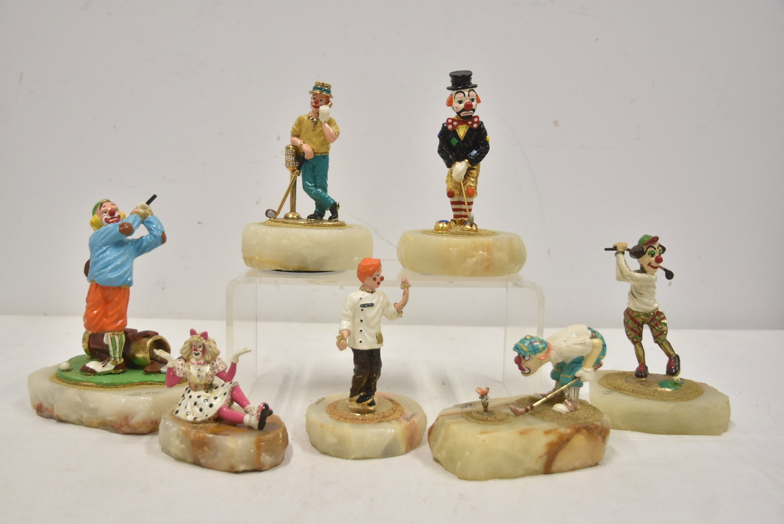 (7) ASSORTED RON LEE GOLF FIGURINE SCULPTURES: (6) RON LEE ENAMELED BRONZE GOLF SCULPTURES RAISED ON ONYX BASES / RON LEE RELCINING CLOWN LADY - LARGEST IS 5 1/2" x 4" x 7 1/2"