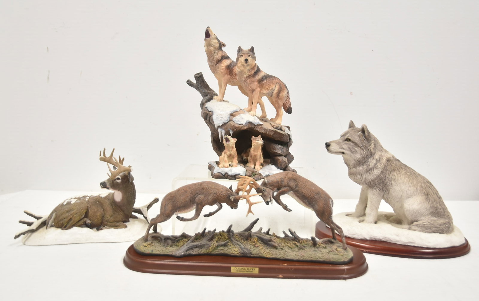 (4) WILDERNESS ANIMAL SCULPTURES: DANBURY MINT "WILDERNESS CALL" SCULPTURE BY NICK BIBBY / SANDICAST SNOW WOLF SCULPTURE / WINTER STAGG BY BOB TRAVERS (ANTLERS HAVE DAMAGE) / DUELING BUCKS BY JAMES STAFFORD - 7 1/2" x 7" x 10 1/2"