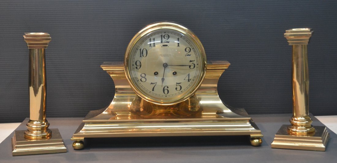 TAMBOUR No. 1 CHELSEA MANTLE CLOCK SET ca. 1903: BOSTON, MASS; CLOCK SILVERED DIAL WITH RAISED ARABIC NUMBERS , SERPENTINE HANDS & 8 DAY TIME AND "HOUSE STRIKE" LEVER ESCAPEMENT HOUSED IN BRASS BALL FOOT CASE WITH (Pr) CANDLESTICKS - CLOCK IS 16 1/2