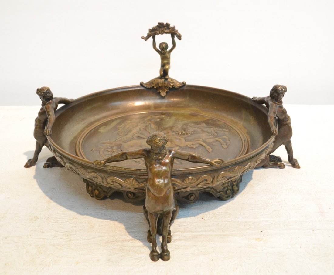 CARVED MYTHOLOGICAL BRONZE CENTER BOWL: WITH MAN IN CHARRIOT MEDALLION SUROUNDED BY PUTTI FIGURE , BEARDED MAN WITH HOOF FORM FEET SIGNED DEBUT - 14" x 7"