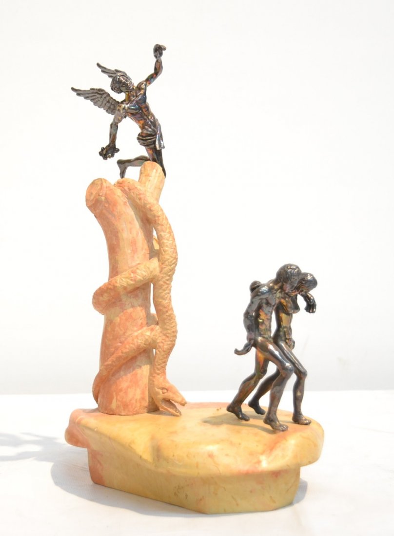 YAACOV HELLER SILVER GROUPING ON ROCK BASE: DEPICTING ADAM & EVE WITH WINGED CUPID FLYING OVER SNAKE FORM PEDESTAL - 6 1/2" x 5" x 10 1/2"