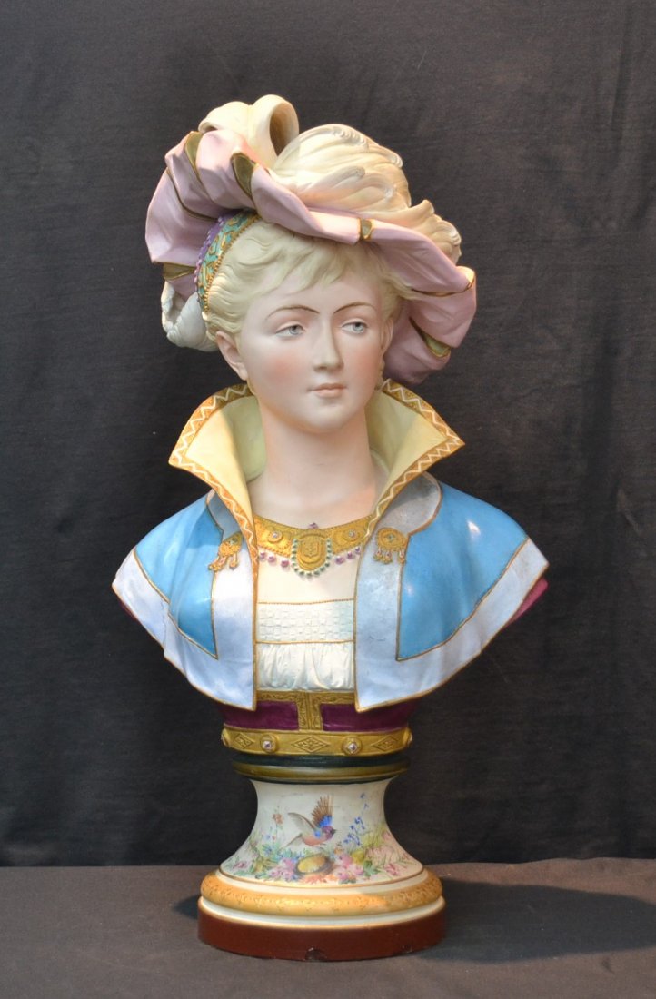 PAUL DUBOY FRENCH HAND PAINTED BISQUE BUST OF: YOUNG WOMAN WEARING PLUMMED HAT & FESTIVE GARMENT WITH GOLD HIGHLIGHTS ; SIGNED PAUL DUBOY ; A & L ; RAISED ON FLORAL & BIRD BASE - 15" x 11" x 28" -
