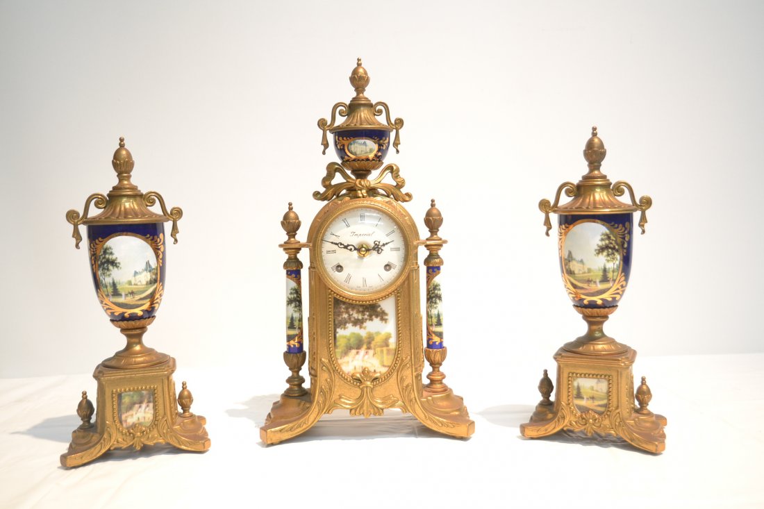 (3)pc FRANZ HERMLE GILT METAL CLOCK SET WITH: PORCELAIN INSERTS & URN TOP - CLOCK IS 9" x 5" x 17" , GARNITURE IS 13 1/2" TALL