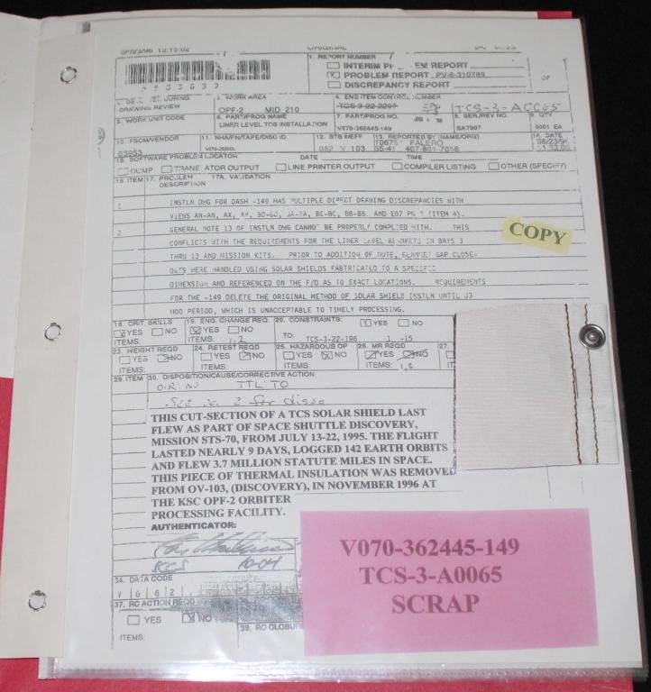 STS-70 Flown Swatch With Copy of Paperwork: A 2.5"x 3" section of TCS solar shield flown aboard Discovery on its STS-70 mission. This section was cut from a larger piece, and a photocopy of the original NASA paperwork is included.