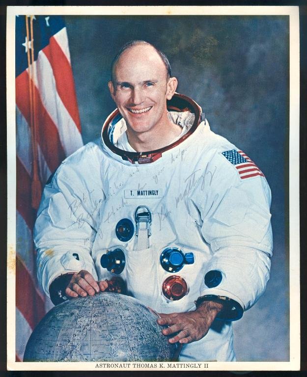 Ken Mattingly Signed NASA Color Litho: An 8"x 10" NASA color litho signed by Apollo 16 astronaut Ken Mattingly. Some minor age spotting on the left white margin. Masking tape stains on the back from being taped to the matte, and the signat