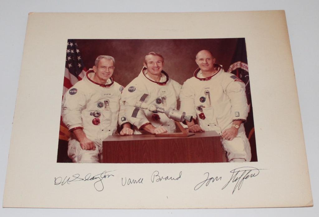 Apollo-Soyuz US Crew-Signed Matted Photo: A 7"x 9.5" glossy photo of the Apollo-Soyuz US crew attached to a 11"x 14" matte board, and signed by Slayton, Brand and Stafford on the matte. Great condition.
