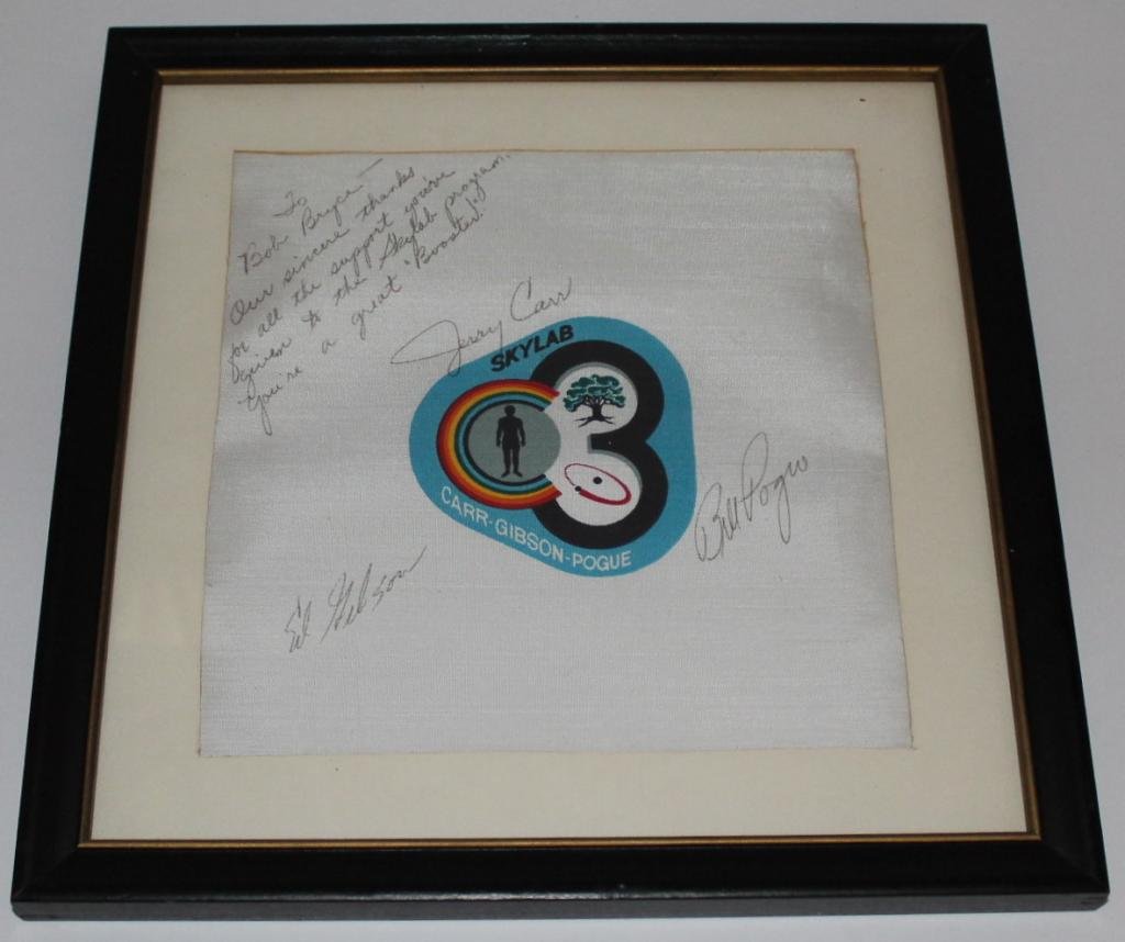 Skylab 4 Crew-Signed Beta Cloth Patch: A Skylab 4 beta cloth patch signed by the crew of Gibson, Carr and Pogue. Contained in a 12"x 12" overall frame. Very fine condition.