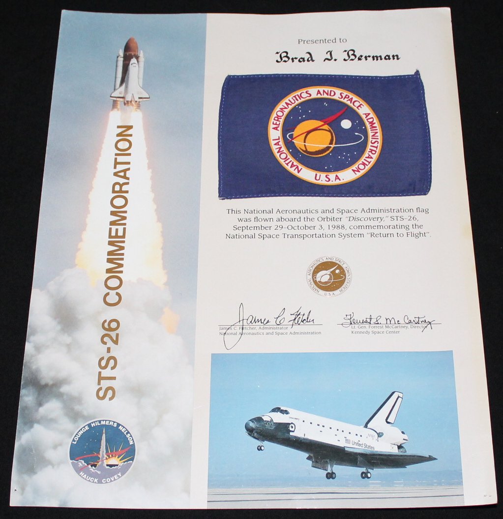 STS-26 Flown Flag: A 4"x 6" NASA Headquarters flag flown into space aboard Discovery on its STS-26 Return to Space mission in 1998, and it is attached to an 11"x 14" certificate. There are left edge handling dings and p
