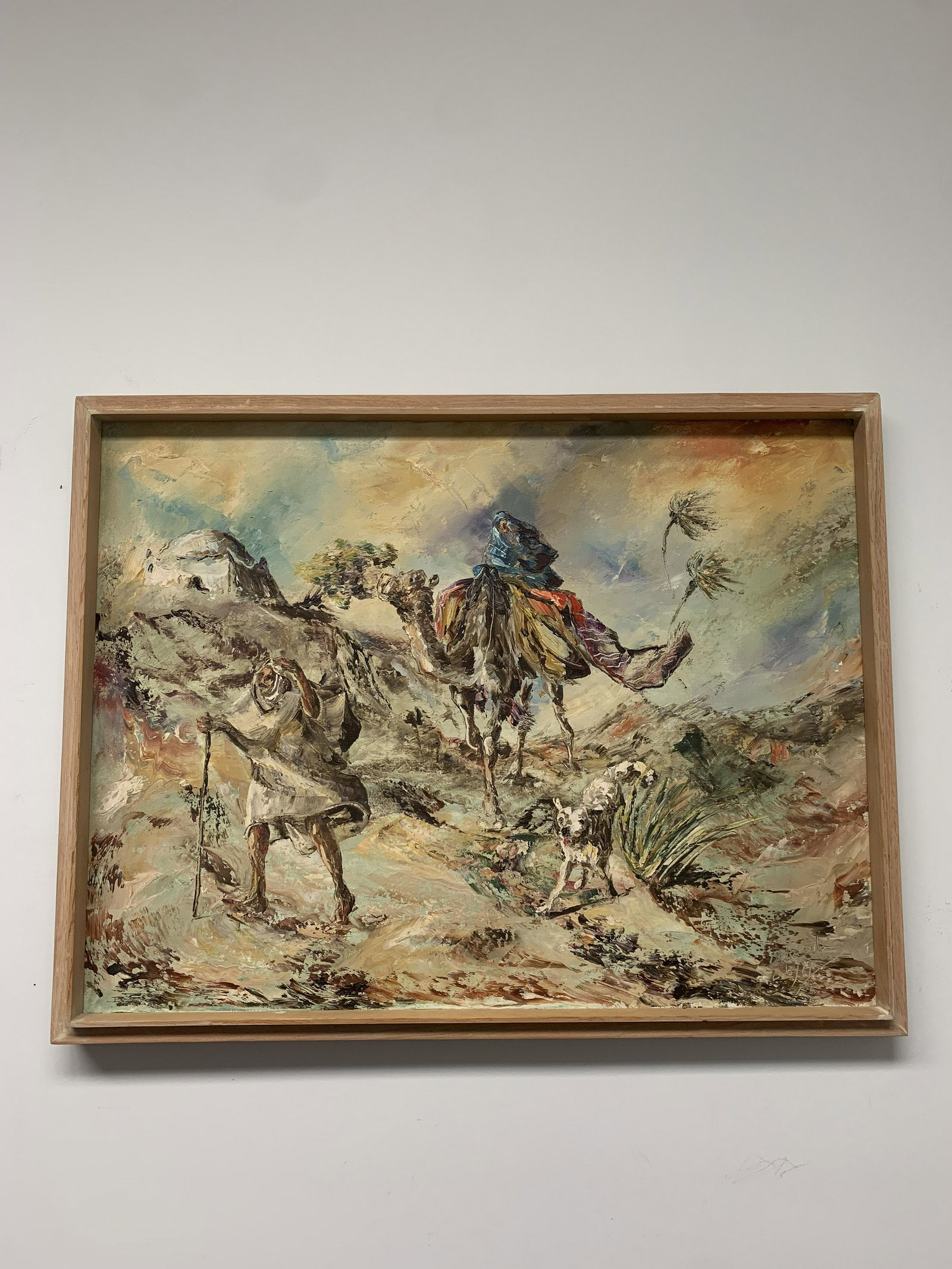 Framed Canvas Painting of Man Riding Camel: Framed canvas painting of a man riding a camel with a dog and friend alongside him in wind. Size: 33 x 25 Inches