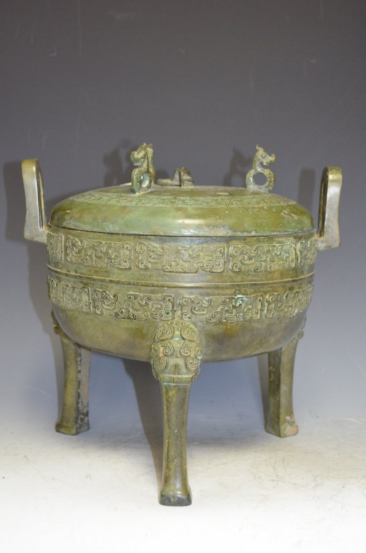 Chinese Bronze Tripod Lidded Ding: Chinese Bronze Tripod Lidded Ding with Lid. Lid has a Ring Handle at center of top surrounded by Three Stylized Dragon Handles. H: 11 Inches