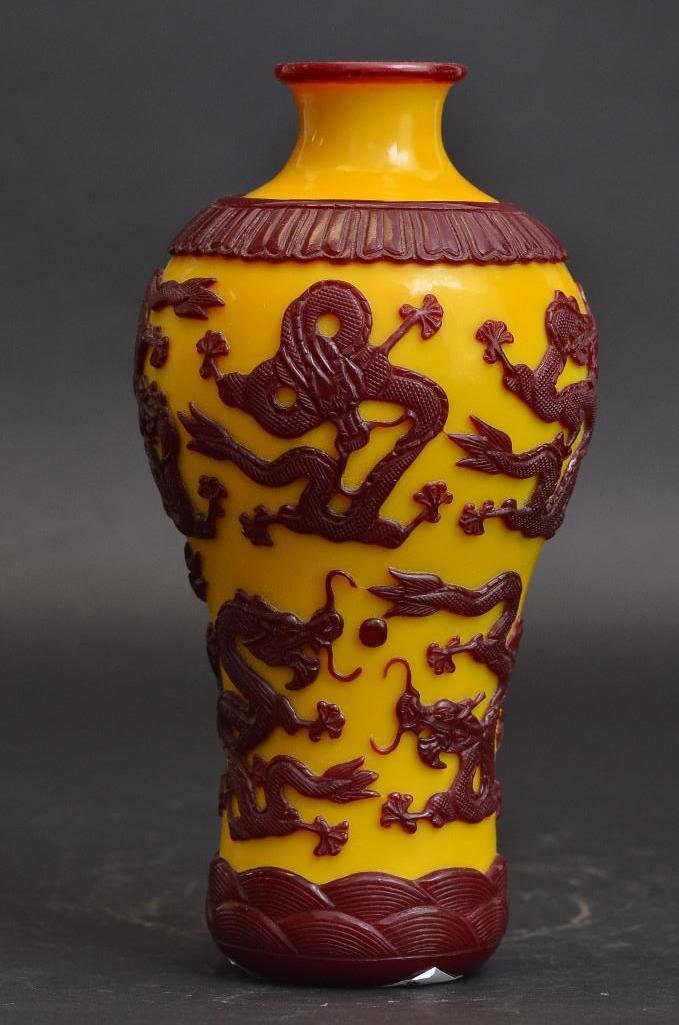 Chinese Peking Glass Yellow Ground with Red Overlay: Chinese Peking Glass Yellow Ground with Red Overlay Vase. The carved red glass overlay depicts dragons chasing a flaming pearl; H: 10.5 Inches