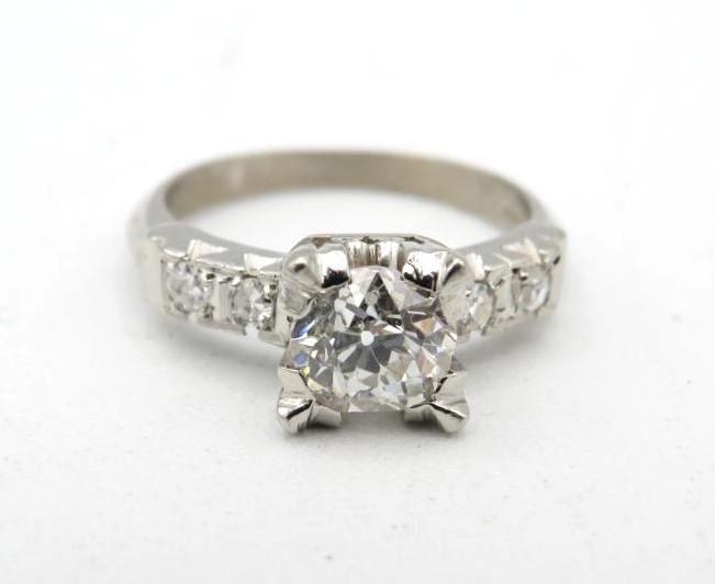 Platinum and Diamond Ring: 5.92-6.3mm (.98+/- carat) round cut center diamond with (2) 2.55mm diamonds on each shoulder, size 5.25, 5.1 grams total weight, small chip under prong