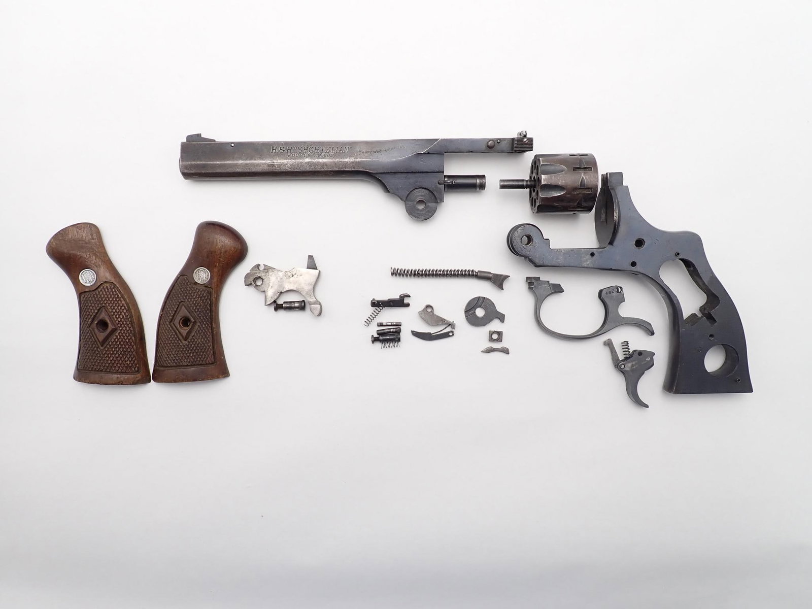 Harrington and Richardson Sportsman Revolver: SN: T21482 Year of Mfg: 1932-1986 Cal: .22 LR Action Type: Double Action Barrel Length: 6" Sights/Optics: Factory sights Stock: Wood grips Finish: Blued Finish Cond: Original, worn in places Bore: