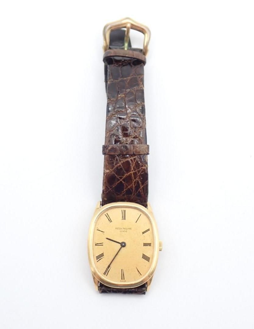 Patek Philippe 18K Yellow Gold Gent's Wrist Watch: the case being approx. 32mm x 27mm, the later band without gold hardware