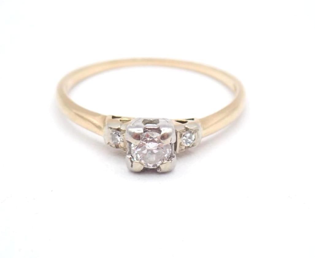 14K Yellow and White Gold and Diamond Ring: 3.5mm round cut center diamond with 1.5mm round cut diamond on each shoulder, 1.27 grams total weight