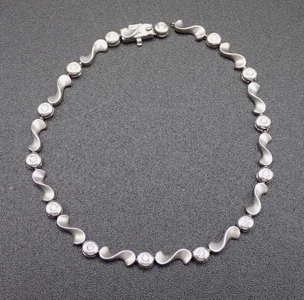 14K White Gold and Diamond Bracelet: with (14) 1.5mm+/- bezel set round cut diamonds; 7.5" in length; 7.7 grams total weight; needs mending