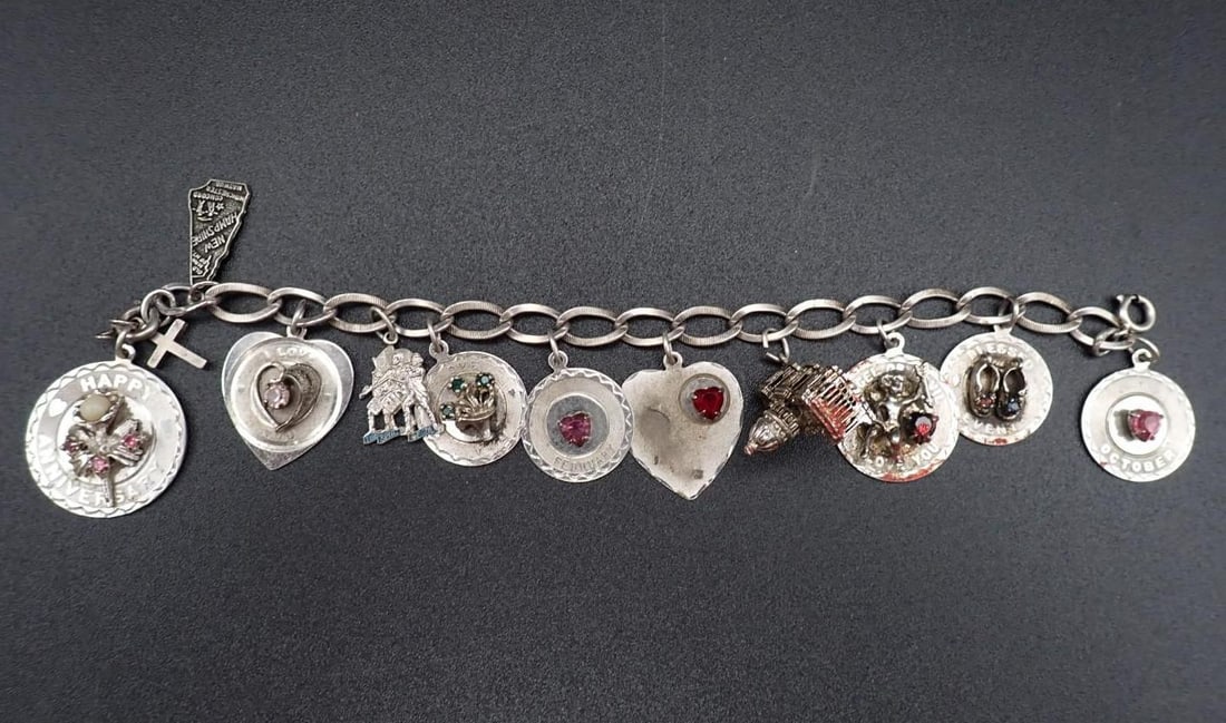 Sterling Silver Charm Bracelet: 41.6 grams total weight, capitol building and (1) of the hearts may not be sterling