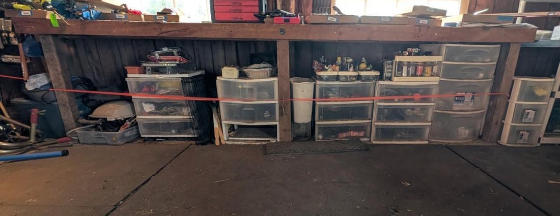 Contents Under Workbench: includes: (5) multi drawer storage bins w/ contents, LP grill, Painting sundries, bike repair, fasteners, cord, sprays and lubricants, tools, more..., Location: Garage