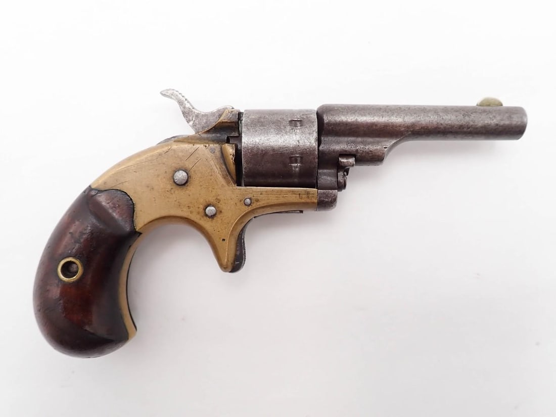 Colt Open Top Pocket Model Revolver: SN: 86873 Cal: .22 Action Type: Single Action Barrel Length: 2 3/8" Sights/Optics: fixed blade front Stock: smooth walnut Finish: brass & blue Bore: fair Overall Cond: fair Mechanical: fair,