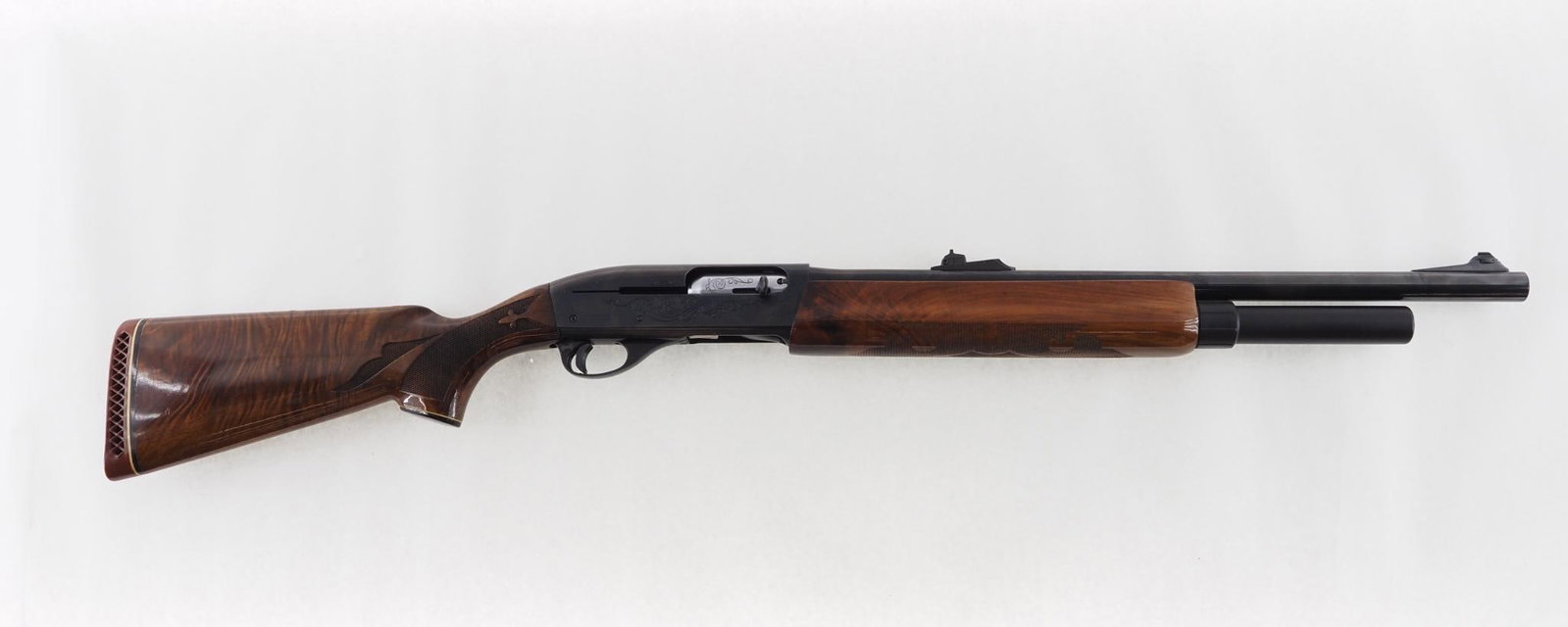 Remington 1100 Shotgun: SN: M419147V Cal: 12 Ga. Action Type: Semi-Automatic Barrel Length: 21" with rifled choke tube Sights/Optics: adjustable rear sight Stock: fancy wood with pressed checkering and a few minor blemishes