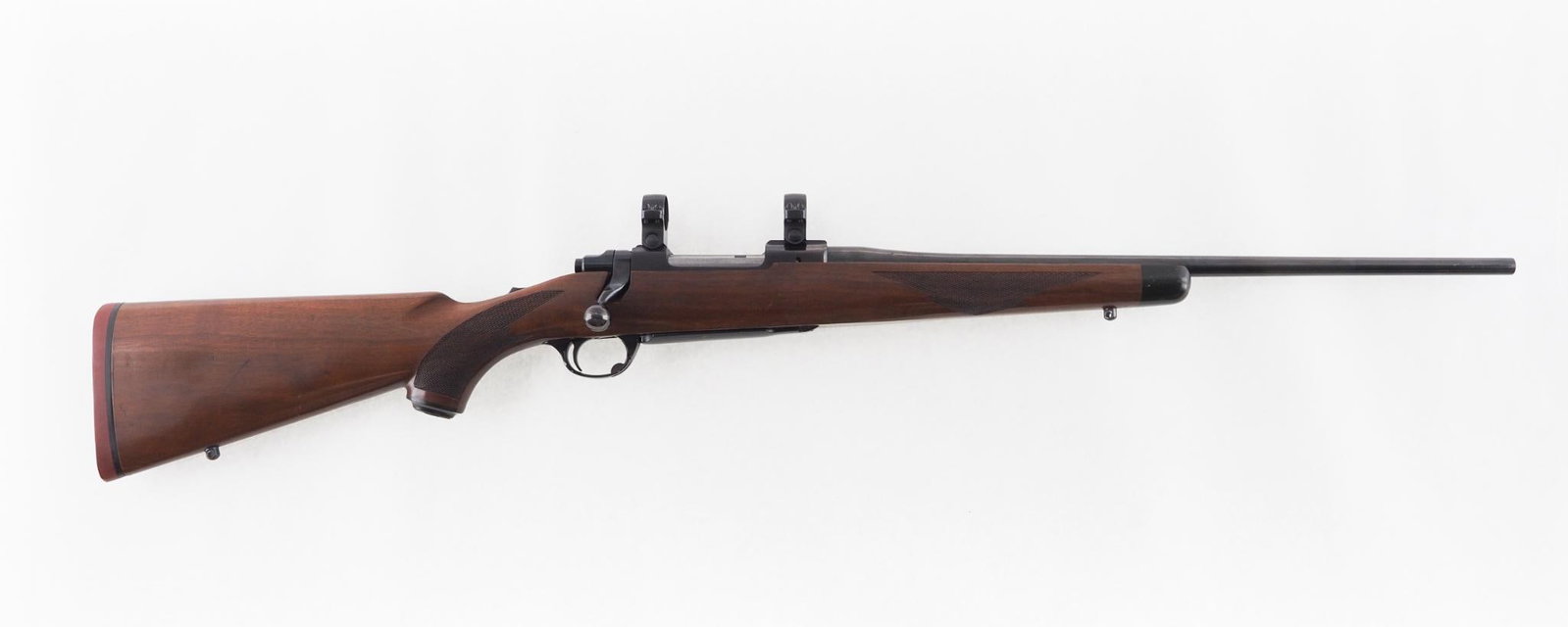 Ruger M77 Rifle: SN: 79-85983 Cal: .250-3000 Action Type: Bolt Action Barrel Length: 20" Sights/Optics: 1" scope rings Stock: checkered walnut with light handling marks Finish: strong blue with a few minor blemishes