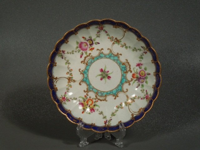 First Period Worcester Fluted Saucer Circa 1772: Superb 18th century Worcester fluted saucer dish. Royal blue border and floral sprays. Centered with a rose and a turquoise diaper frame with gold rim and accents. Crescent mark to base. Measures 5 1/