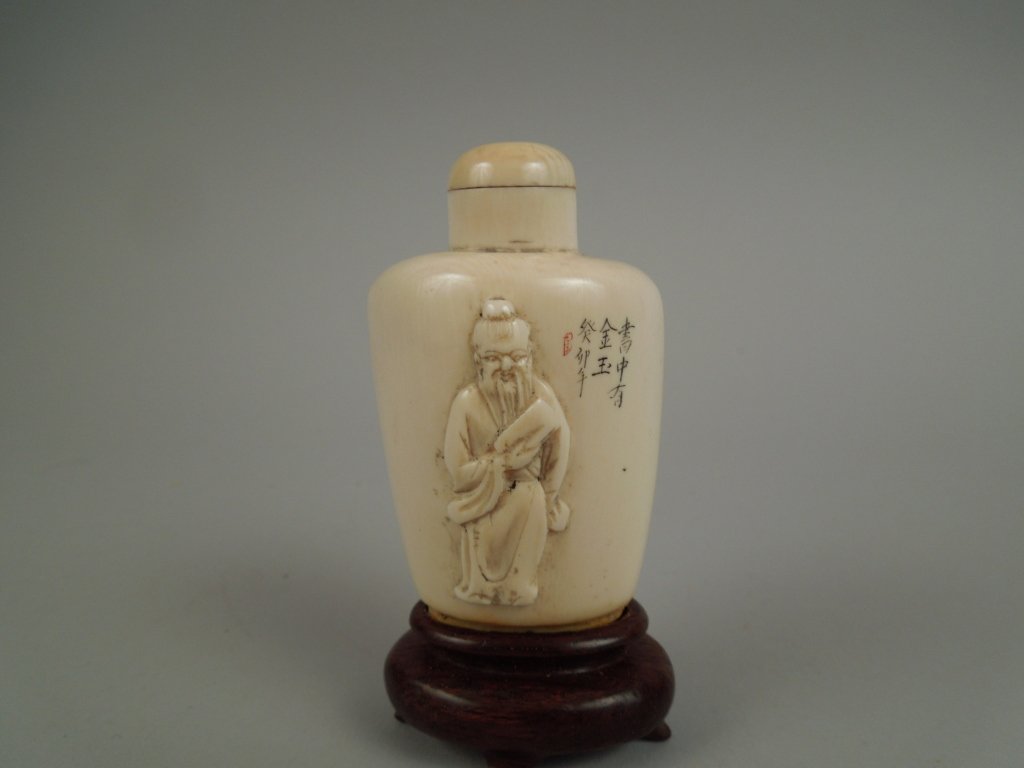 Vintage Chinese Carved Ivory Snuff Bottle: Vintage Chinese carved ivory snuff bottle; on wooden base. measures 2 1/2" without base; International shipping is not available for this item. This item will only be shipped within the United States.