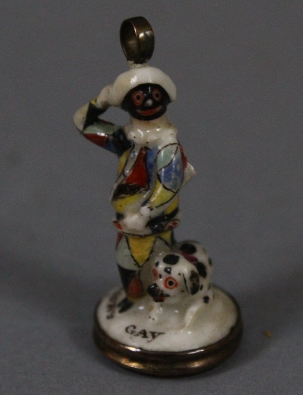 Miniature Harlequin Porcelain Seal ca. 1750-1760: Miniature circa 1750-1760 Seal of soft-paste porcelain, painted with enamels, in the form of Harlequin, masked, in a parti-coloured dress with a dog, and with a carnelian intaglio of a cherub with the