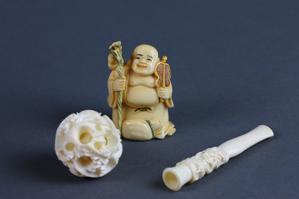 3.Carved Ivory Puzzle Ball,Netsuke, Cigarette Tip: Three pieces of Carved Ivory Puzzle ball,signed Netsuke and a carved Cigarette tip, measuring (7.75cm) 3'' in length.