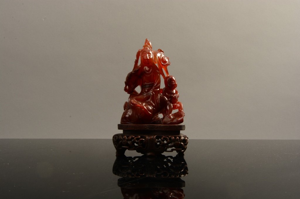 Chinese Qing Dynasty Carved Carnelian Guanyin: Chinese Qing dynasty carved carnelian Guanyin on a pierced and carved base; measures 5 1/4" tall.