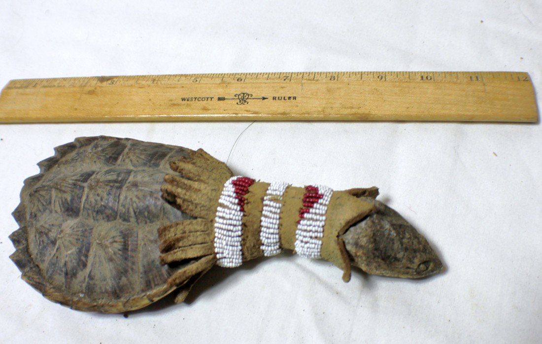 Native American Collectibles: Original Sioux Indian Turtle back rattle, with leather and beaded handle. Approximately 9 inches long