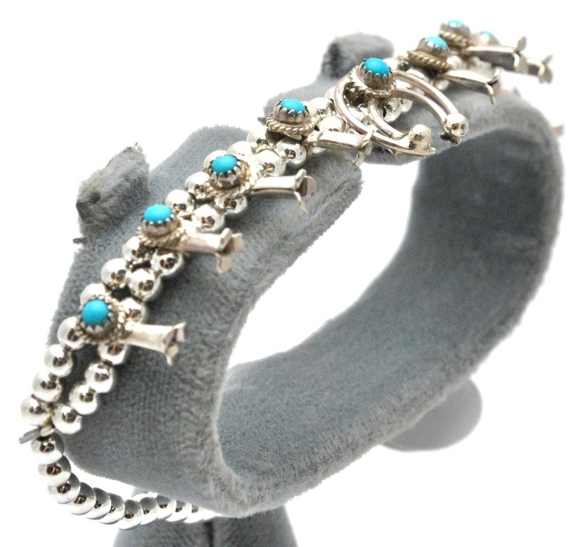 Navajo Turquoise Sterling Silver Squash Blossom Bracele: Navajo Turquoise Sterling Silver Squash Blossom Bracelet - Larry Curley Measures 7 long. Blossoms measure 3/8" tall by 1/8" wide. Naja measures 1/2" tall by 9/16" wide. Weight: 9.2g SKU: br0331"