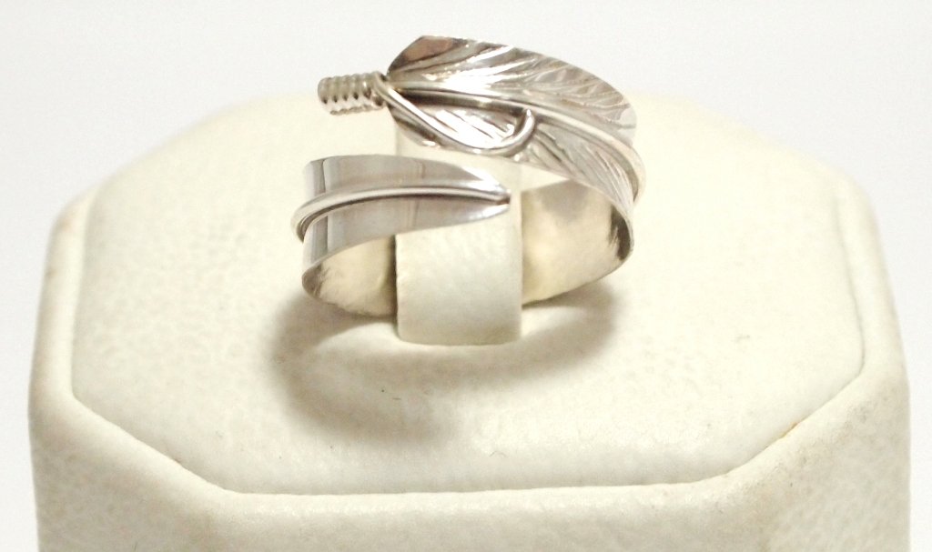 Navajo Sterling Silver Feather Adjustable Women's Ring : Navajo Sterling Silver Feather Adjustable Women's Ring - Chris Charley Measures 1/4 wide. Ring is flexible, default size 6.5 to 7. When bending ring, size ranges from 4 to 11 (ring separates beyond si