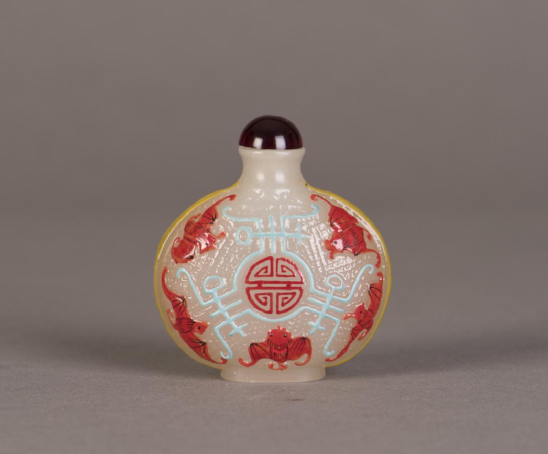A PEKING GLASS SNUFF BOTTLE OF FORTUNE AND LONGEVITY: A peking glass snuff bottle with symbolic relief representing fortune and longevity, brown glass stopper. Height 2.75" Width 2.5"s