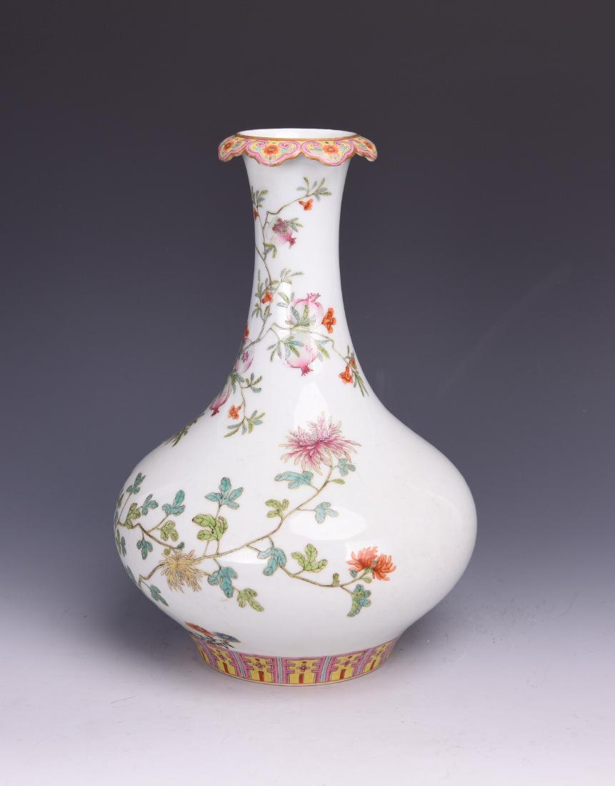 A FAMILLE ROSE PORCELAIN VASE: The compressed globular porcelain body supported on a wide foot to a long neck, the rim decorated with a ruyi floral sprays, the body painted with floral pattern. Height 28.3cm