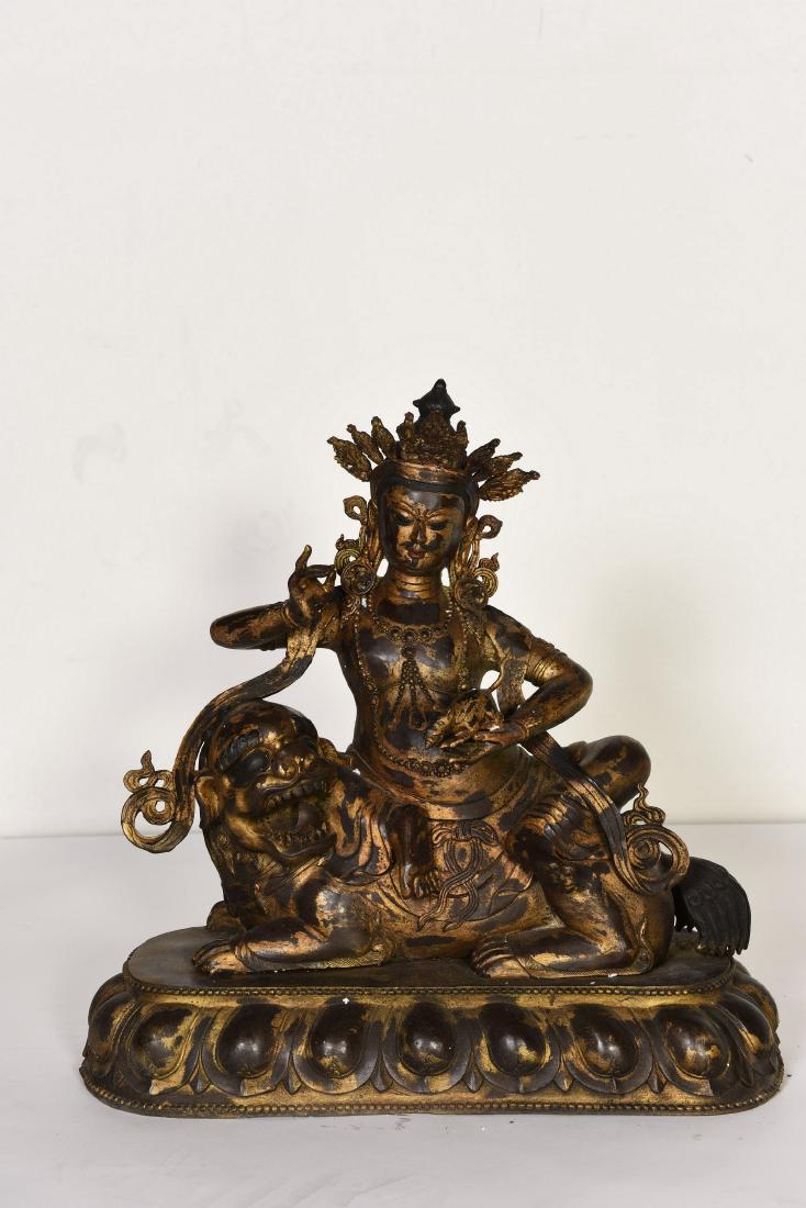 A GILT-BRONZE BUDDHA: A gilt-bronze sculpture of a buddha seated on a beast couching on the lotus base. Height 20" Width 18.5"