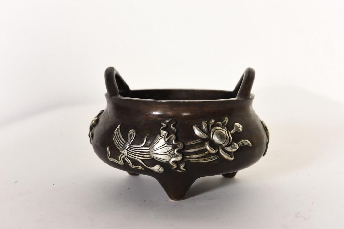A SILVER INLAY INCENSE BURNER: A silver inlay incense burner with side handles raised from the mouth rim and seal mark on base. Height 4.25" Width 6.5â€